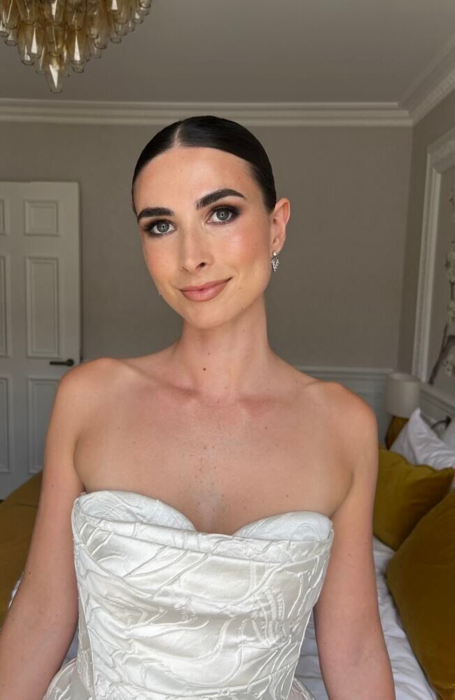 bridal makeup with smokey eyes and sleek bun with mid parting