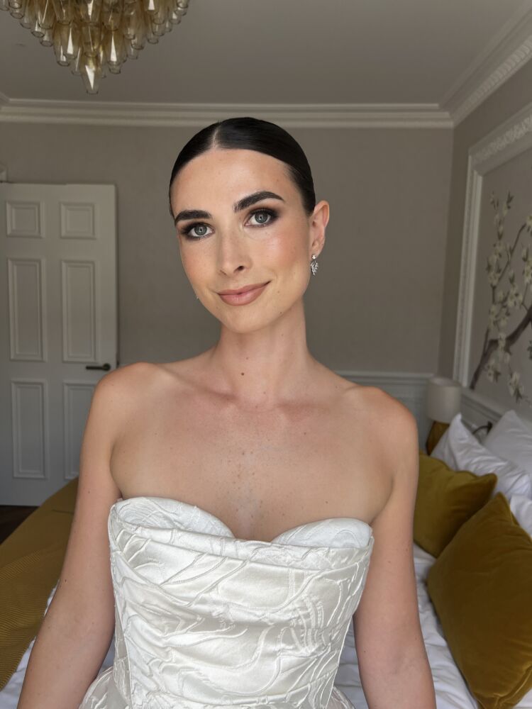 bridal makeup with smokey eyes and sleek bun with mid parting
